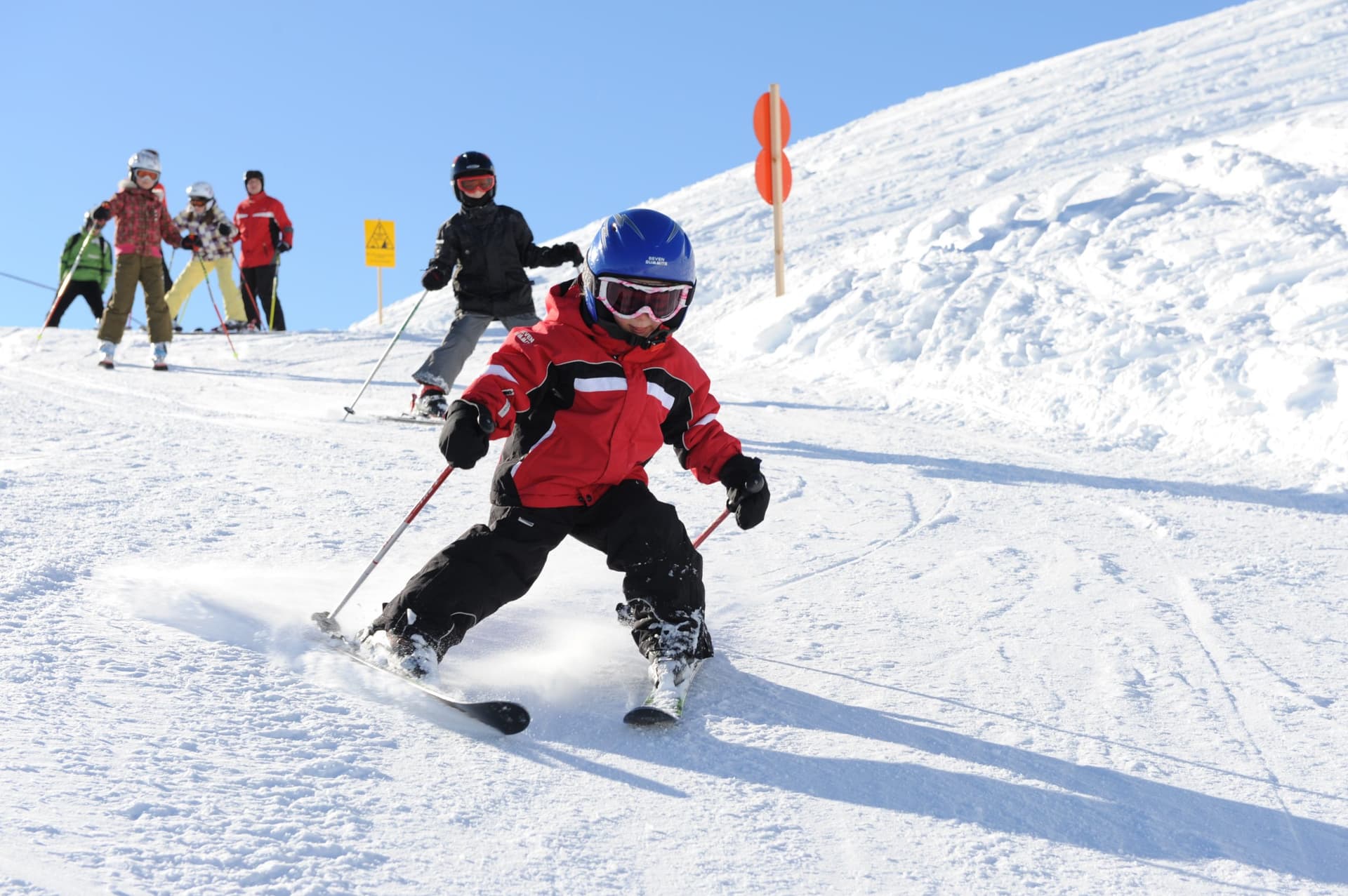 Young child in ski lesson learning how to ski in austria